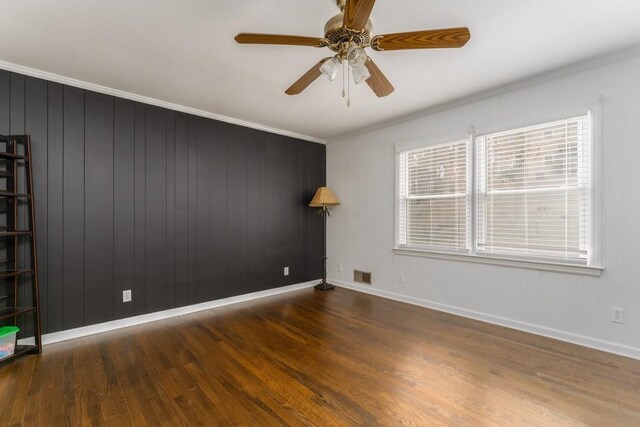 unfurnished room with baseboards, crown molding, visible vents, and wood finished floors