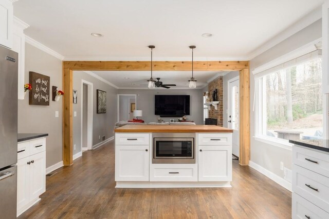 kitchen featuring wood counters, ornamental molding, stainless steel appliances, and wood finished floors