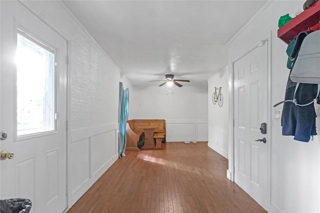 hallway with hardwood / wood-style flooring and crown molding