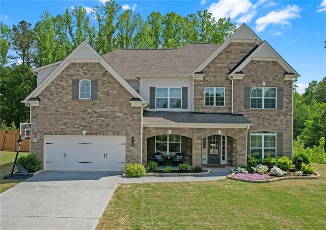 craftsman inspired home with a front lawn, an attached garage, brick siding, a porch, and driveway