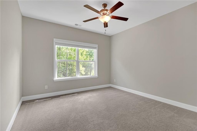 spare room featuring baseboards, ceiling fan, carpet floors, and visible vents