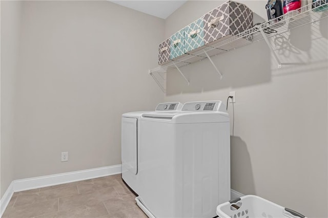 washroom with washer and dryer, laundry area, and baseboards