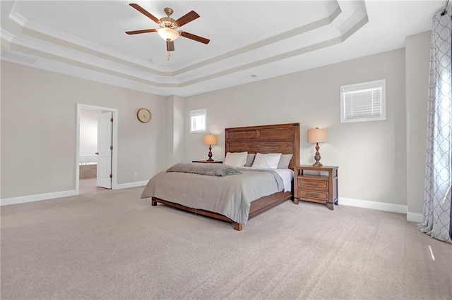 carpeted bedroom with baseboards, ornamental molding, a ceiling fan, and a tray ceiling