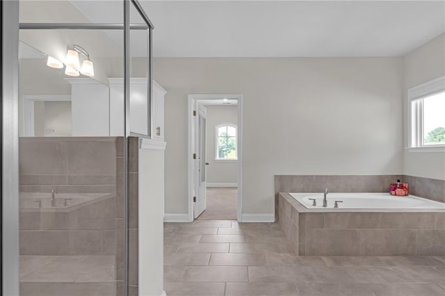 full bathroom featuring plenty of natural light, a bath, and a stall shower