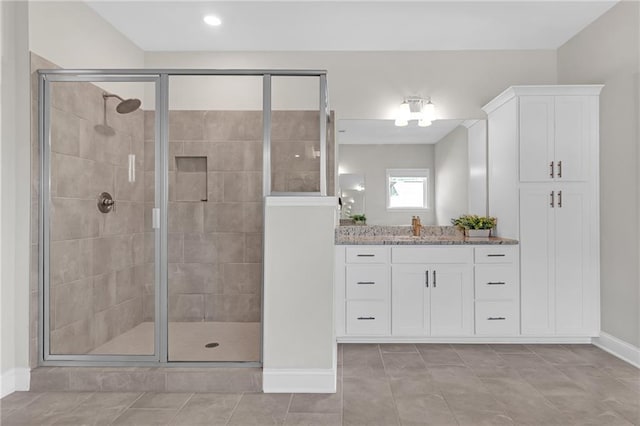 full bathroom featuring baseboards, a shower stall, tile patterned flooring, and vanity