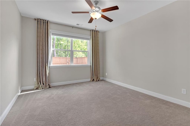 carpeted empty room featuring visible vents, baseboards, and ceiling fan