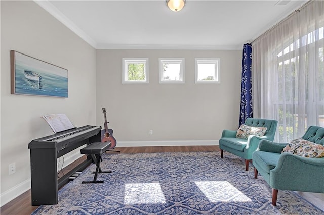 living area featuring crown molding, baseboards, and wood finished floors