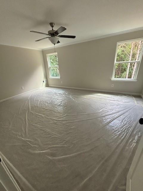 unfurnished room featuring ceiling fan and crown molding