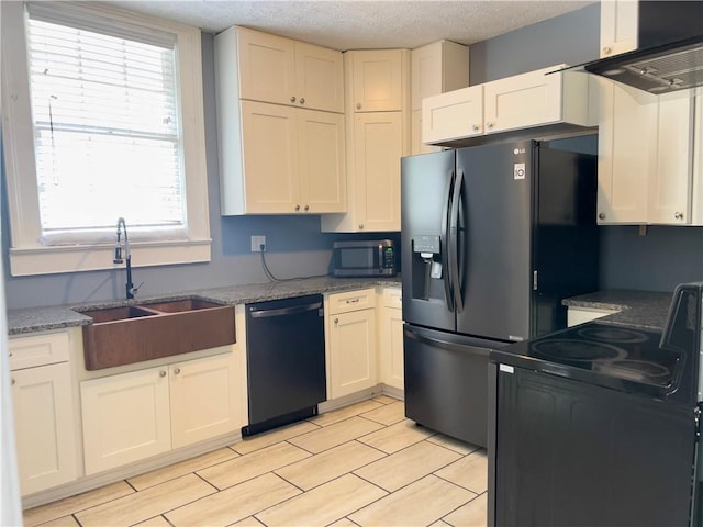 632 Monroe St, Macon, GA 31201 - kitchen with black appliances, a sink, healthy amount of natural light, white cabinets, and a textured ceiling
