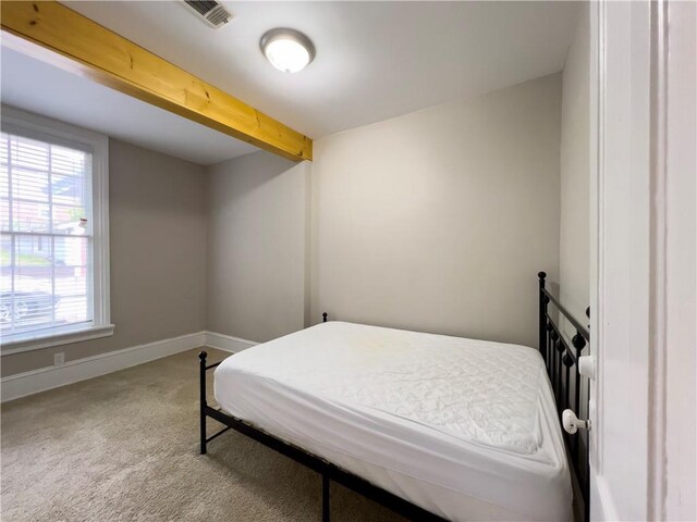 632 Monroe St, Macon, GA 31201 - carpeted bedroom with baseboards and beamed ceiling