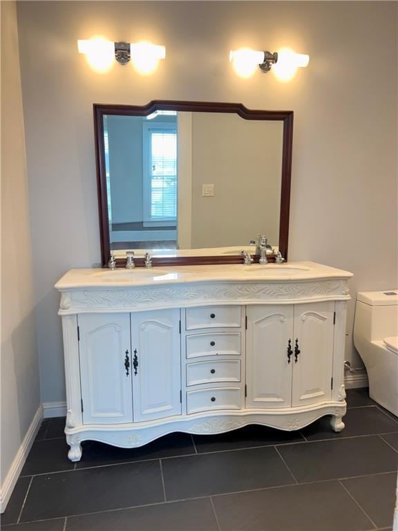 632 Monroe St, Macon, GA 31201 - bathroom featuring double vanity, toilet, tile patterned floors, and baseboards