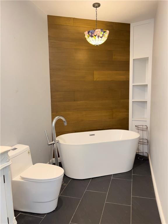 632 Monroe St, Macon, GA 31201 - full bathroom featuring wooden walls, a freestanding bath, vanity, tile patterned floors, and toilet