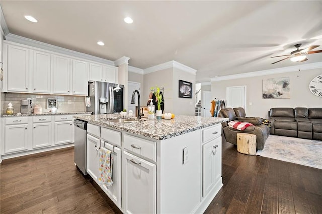 kitchen featuring white cabinetry, sink, dark wood-type flooring, stainless steel appliances, and a kitchen island with sink