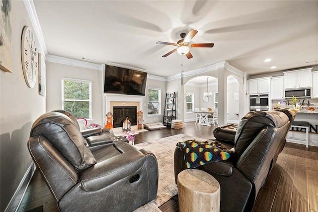 living room with crown molding, ceiling fan, and dark hardwood / wood-style floors