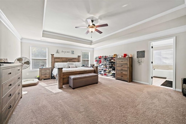 carpeted bedroom with ensuite bath, ceiling fan, crown molding, and multiple windows