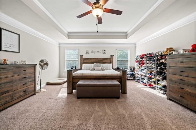 carpeted bedroom featuring multiple windows, a raised ceiling, and ceiling fan