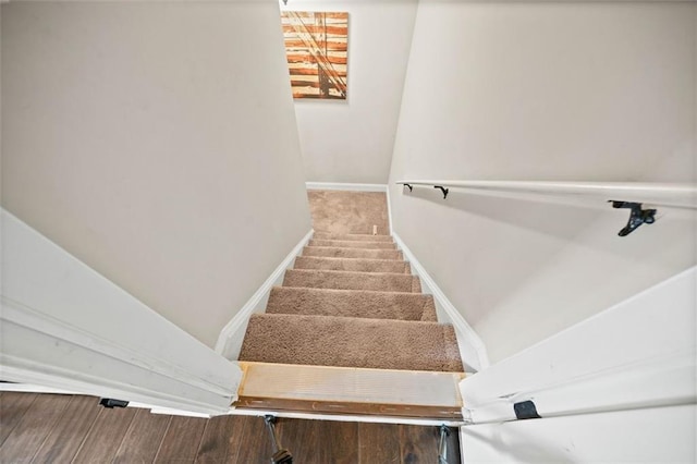 staircase featuring hardwood / wood-style floors and vaulted ceiling