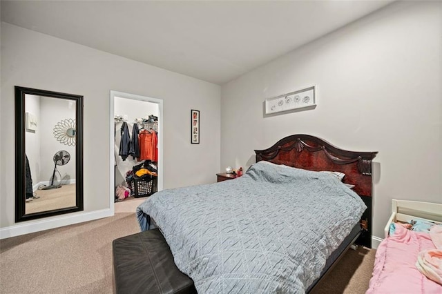 carpeted bedroom featuring a walk in closet and a closet