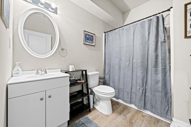 bathroom with a shower with shower curtain, wood-type flooring, vanity, and toilet