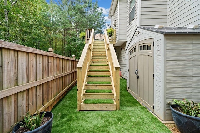 view of playground featuring a storage shed and a yard