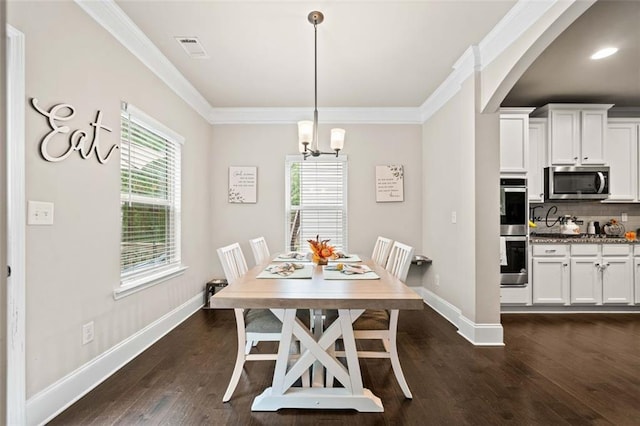 dining room featuring dark hardwood / wood-style floors, an inviting chandelier, and ornamental molding