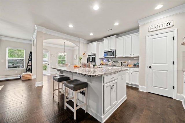 kitchen with white cabinetry, an island with sink, stainless steel appliances, and dark hardwood / wood-style floors