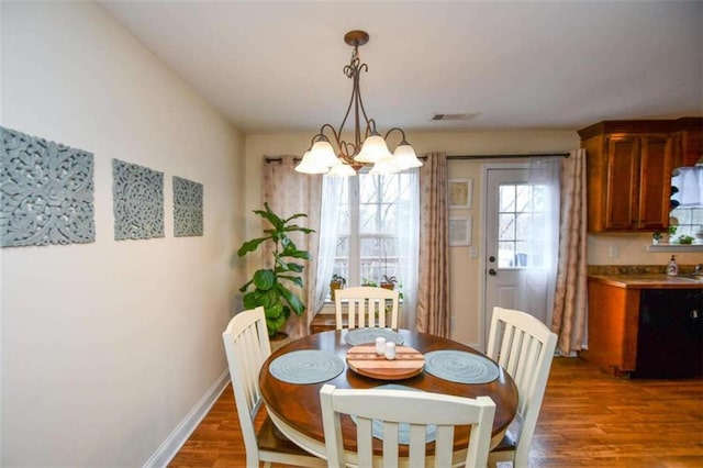 dining area with a notable chandelier and dark hardwood / wood-style flooring