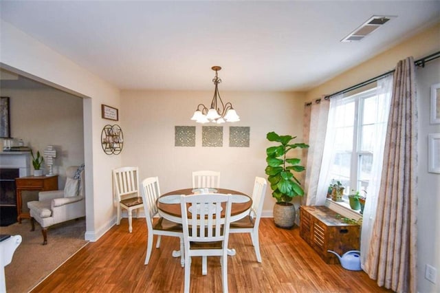 dining room featuring hardwood / wood-style flooring and an inviting chandelier