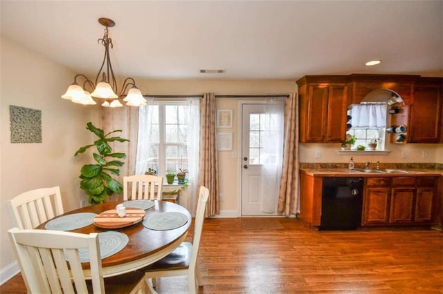 dining area with an inviting chandelier, sink, and hardwood / wood-style floors