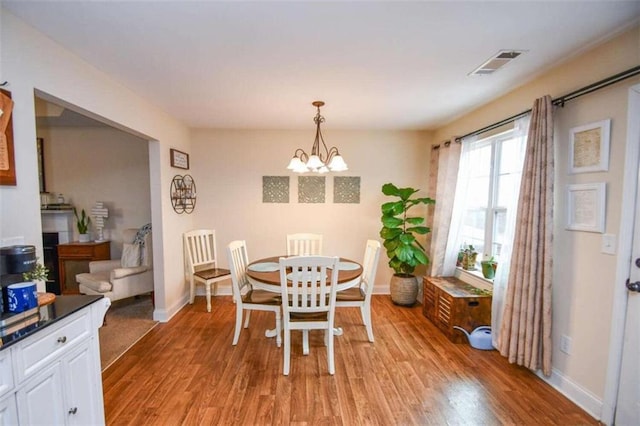 dining area with an inviting chandelier and light hardwood / wood-style flooring