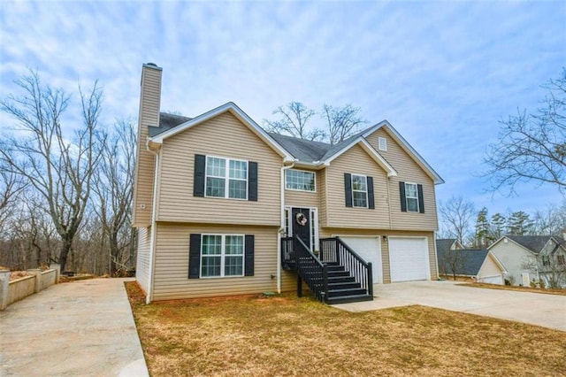 bi-level home featuring a garage and a front lawn