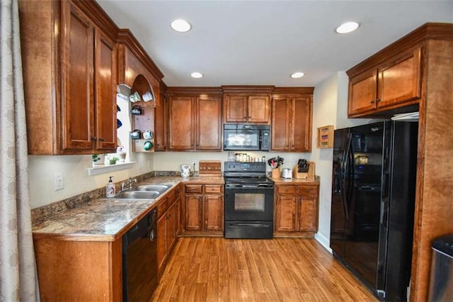 kitchen with sink, light hardwood / wood-style flooring, and black appliances