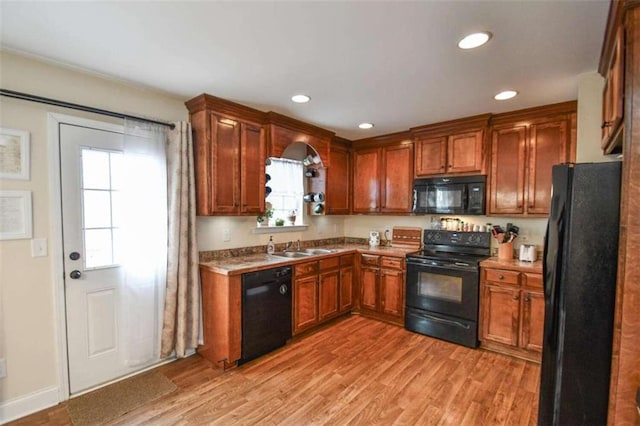 kitchen with sink, black appliances, and light hardwood / wood-style floors