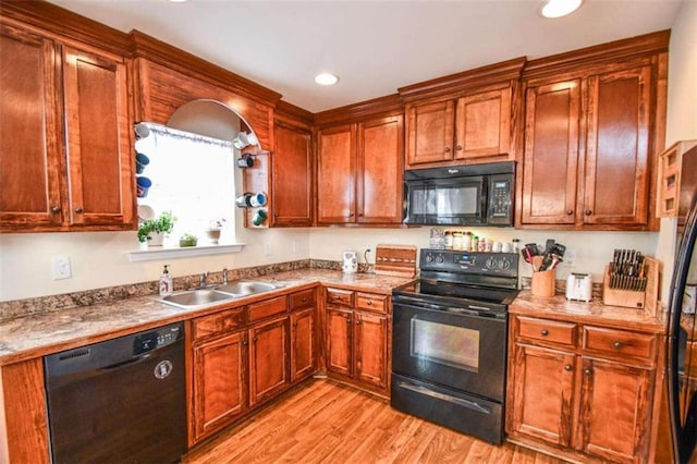 kitchen featuring sink, black appliances, and light hardwood / wood-style floors