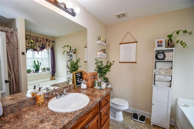 bathroom with vanity, a washtub, and toilet