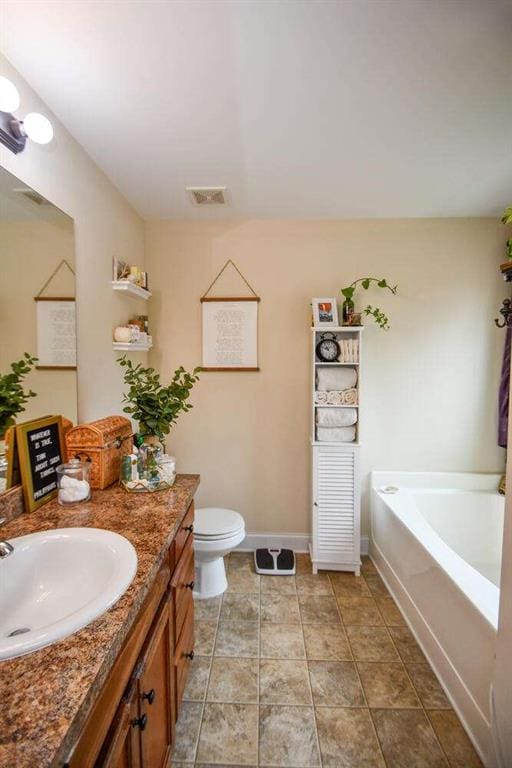 bathroom featuring toilet, vanity, and a bath