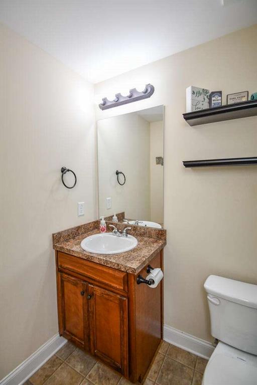 bathroom featuring tile patterned flooring, vanity, and toilet