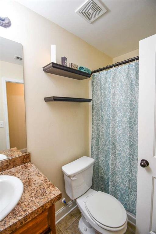 bathroom with vanity, toilet, and tile patterned flooring