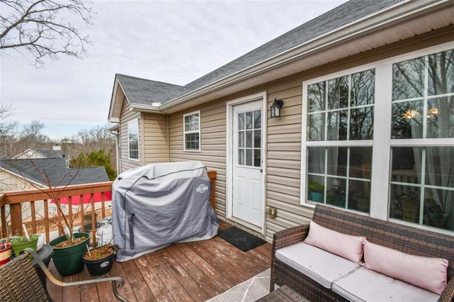 wooden deck with an outdoor hangout area and grilling area