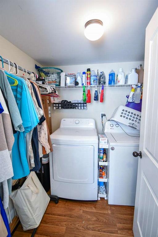 laundry area with dark wood-type flooring and independent washer and dryer