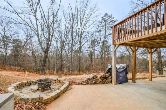 view of patio / terrace with area for grilling, a deck, and an outdoor fire pit