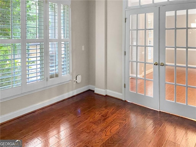 spare room with french doors, dark wood-style flooring, and baseboards