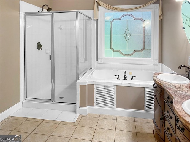 full bathroom featuring tile patterned floors, a stall shower, a garden tub, and a sink