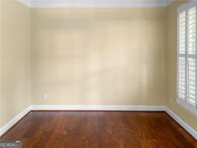 empty room featuring baseboards and dark wood-style flooring