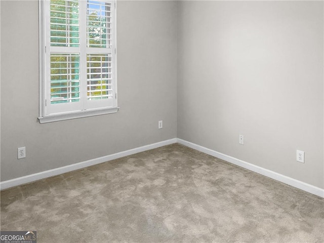 carpeted empty room with baseboards