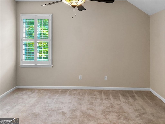 carpeted empty room with lofted ceiling, baseboards, and ceiling fan