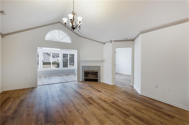 unfurnished living room with a premium fireplace, wood finished floors, baseboards, vaulted ceiling, and crown molding