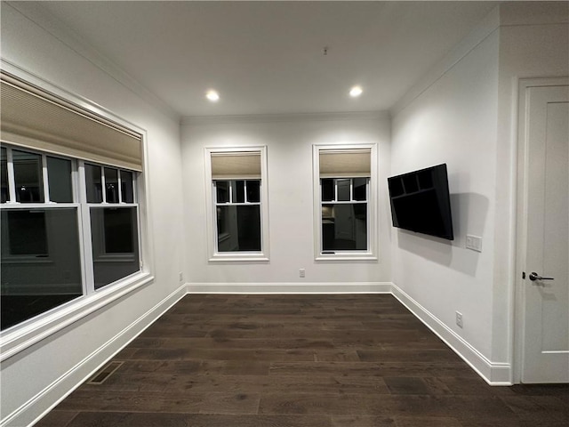 empty room featuring dark wood-type flooring and ornamental molding