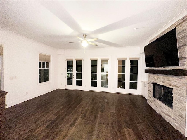 unfurnished living room featuring a fireplace, ceiling fan, french doors, and dark hardwood / wood-style flooring