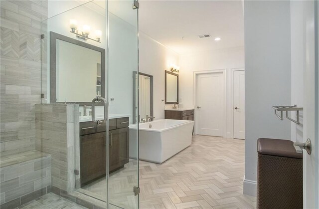 bathroom featuring vanity, parquet flooring, and shower with separate bathtub